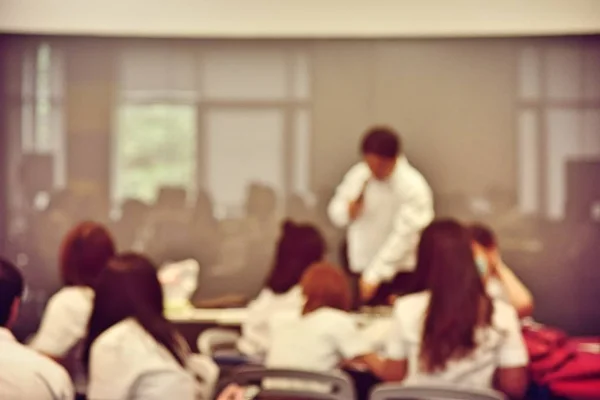 Education concept, Abstract blurred background image of students and business people  studying and discuss in large hall profession seminar with screen and projector for showing information.