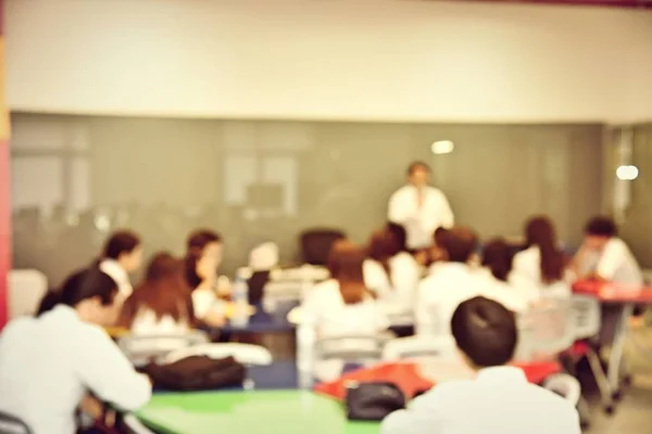 Education concept, Abstract blurred background image of students and business people  studying and discuss in large hall profession seminar with screen and projector for showing information.