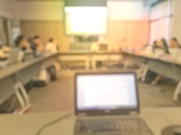 Education concept, Abstract blurred background image of students and business people  studying and discuss in large hall profession seminar with screen and projector for showing information.