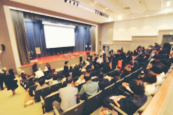 Blurred image of business Conference and Presentation with public presentations. Audience at the conference hall. Entrepreneurship club. Background blur. vintage tone with orange light effect.