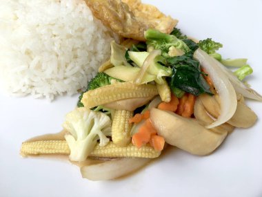 Ahşap arka plan beyaz bir tabağa omlet ile kızartma sebze ilave edin. Tay tarzı yiyecek. Vejetaryen yiyecekler