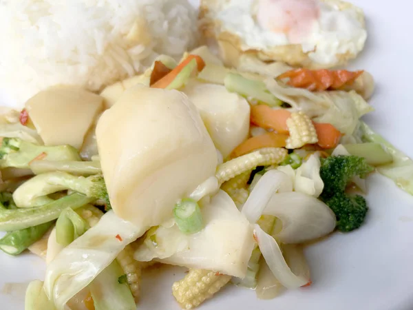 Tofu ve ahşap arka plan üzerinde beyaz tabak pirinç kızarmış yumurta ile tavada kızartılmış karışık sebze. Vejetaryen yiyecekler, sağlıklı gıda.