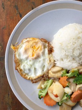 kızarmış sebze tofu karışık pirinç ve ahşap arka plan üzerinde beyaz tabak kızarmış yumurta. Vejetaryen yiyecekler, sağlıklı gıda.