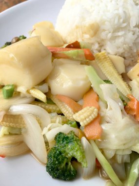 Tofu ve ahşap arka plan üzerinde beyaz tabak pirinç kızarmış yumurta ile tavada kızartılmış karışık sebze. Vejetaryen yiyecekler, sağlıklı gıda.