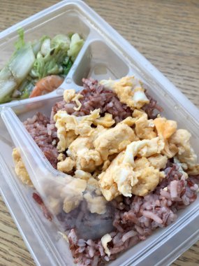 pirinç berry, domuz rostosu, omlet, ahşap arka plan üzerinde kızarmış sebze ile öğle yemeği kutusundaki temiz gıda.