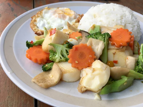 kızarmış sebze tofu karışık pirinç ve ahşap arka plan üzerinde beyaz tabak kızarmış yumurta. Vejetaryen yiyecekler, sağlıklı gıda.
