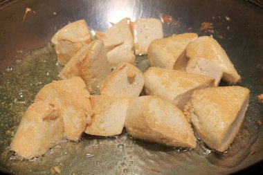 Pişirme tofu kızartma yağı, soya peyniri kızartma adet özel bir ızgarada pişirme süreci mutfakta pan. Vejetaryen yemekleri. Soya soya peyniri ızgara. Kızarmış Tofu tarifi, yumuşak odak.