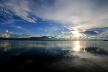 Güzel gün batımı ve dağ ve bulutlar ve Günbatımı ile akşam gökyüzü arka plan için göle yansıyan. Kırsal manzara renkli gökyüzü gün batımında altında şafak Sunrise.