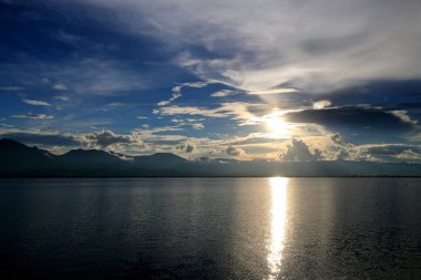 Güzel gün batımı ve dağ ve bulutlar ve Günbatımı ile akşam gökyüzü arka plan için göle yansıyan. Kırsal manzara renkli gökyüzü gün batımında altında şafak Sunrise.