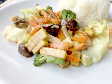 Karıştırın kızarmış Tofu Çin tarzı, derin kızarmış Tofu ile et suyu sosu, tofu karışık sebze ve beyaz arka plan üzerinde beyaz tabak içinde kızarmış yumurta ile karıştırın kızarmış. Vejetaryen yiyecekler, sağlıklı gıda.