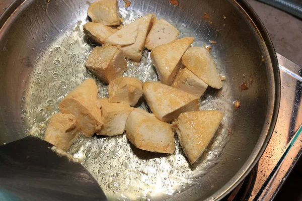 Pişirme tofu kızartma yağı, soya peyniri kızartma adet özel bir ızgarada pişirme süreci mutfakta pan. Vejetaryen yemekleri. Soya soya peyniri ızgara. Kızarmış Tofu tarifi, yumuşak odak.