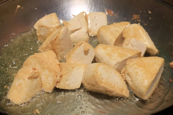 Pişirme tofu kızartma yağı, soya peyniri kızartma adet özel bir ızgarada pişirme süreci mutfakta pan. Vejetaryen yemekleri. Soya soya peyniri ızgara. Kızarmış Tofu tarifi, yumuşak odak.