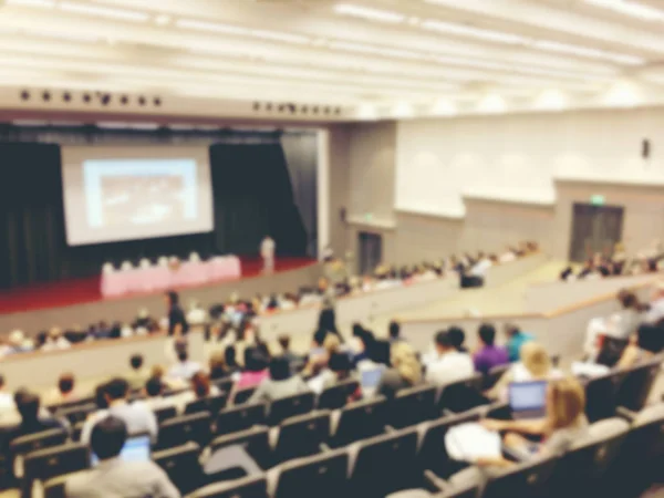 blurred image of Business Conference and Presentation. People Meeting Conference Seminar, Audience at the conference hall. - interior of a conference hall, warm & vintage tone photo.