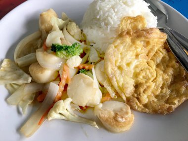 Kızarmış tofu sebze ile Tayland Yasemin pirinç ahşap arka plan üzerinde beyaz tabak ile. Gıda Tay tarzında. Vejetaryen yiyecekler.