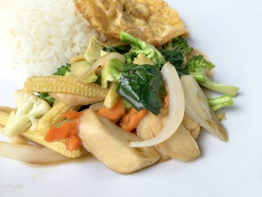 Ahşap arka plan beyaz bir tabağa omlet ile kızartma sebze ilave edin. Tay tarzı yiyecek. Vejetaryen yiyecekler