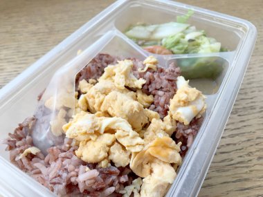 pirinç berry, domuz rostosu, omlet, ahşap arka plan üzerinde kızarmış sebze ile öğle yemeği kutusundaki temiz gıda.