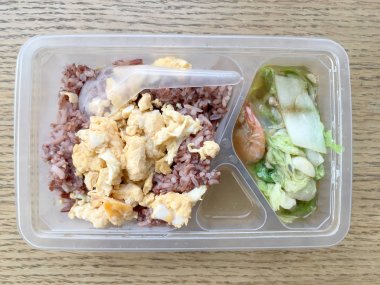 pirinç berry, domuz rostosu, omlet, ahşap arka plan üzerinde kızarmış sebze ile öğle yemeği kutusundaki temiz gıda.