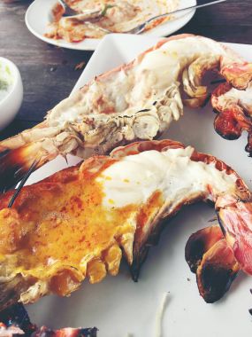 Lezzetli ızgara dev nehir karides adet biber ve maydanoz merkezinde, ahşap masa, küçük kase Soya soslu beyaz çanak üzerinde yukarıdan görüntüleyin. Tay tarzında gıda.