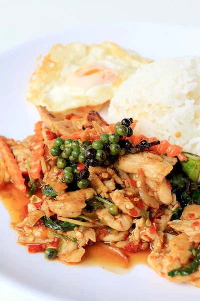 Yasemin pirinç beyaz arka plan üzerinde beyaz tabak içinde kavrulmuş chili Yapıştır ve taze Piper nigrum kızarmış tavuk karıştırın. Tay tarzında gıda.