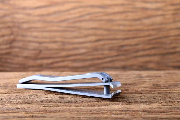 Steel nail clippers on wooden table — Stock Photo, Image