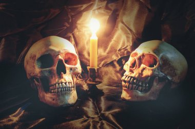 Kafatası pranga ve doku ile siyah kumaş üzerine mum mum loş ışık gece ışık ile natürmort. mum gece zamanında ışık görüntü sesi.