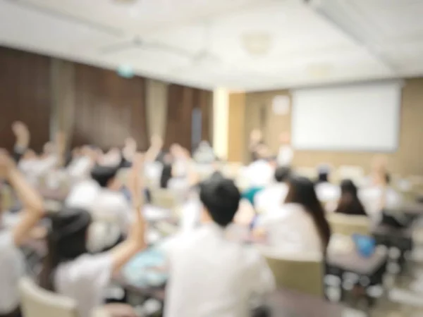 Education concept, Abstract blurred background image of students and business people  studying and discuss in large hall profession seminar with screen and projector for showing information.