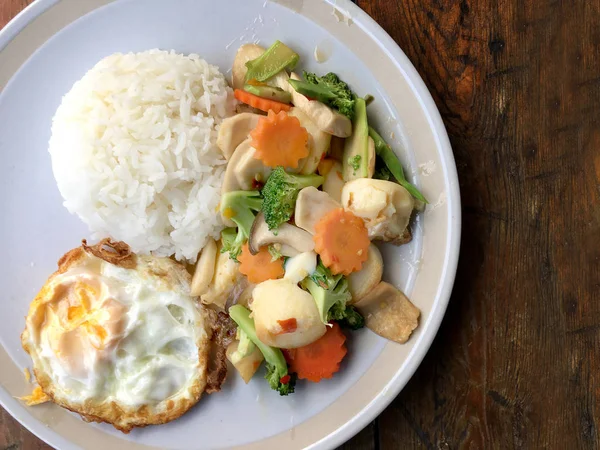 kızarmış sebze tofu karışık pirinç ve ahşap arka plan üzerinde beyaz tabak kızarmış yumurta. Vejetaryen yiyecekler, sağlıklı gıda.