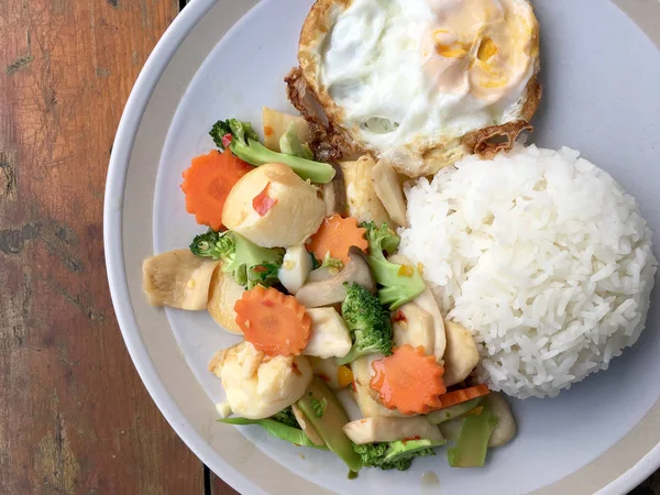 kızarmış sebze tofu karışık pirinç ve ahşap arka plan üzerinde beyaz tabak kızarmış yumurta. Vejetaryen yiyecekler, sağlıklı gıda.
