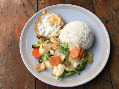 kızarmış sebze tofu karışık pirinç ve ahşap arka plan üzerinde beyaz tabak kızarmış yumurta. Vejetaryen yiyecekler, sağlıklı gıda.