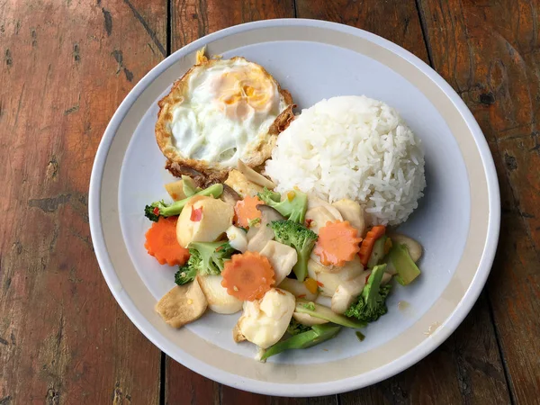 kızarmış sebze tofu karışık pirinç ve ahşap arka plan üzerinde beyaz tabak kızarmış yumurta. Vejetaryen yiyecekler, sağlıklı gıda.