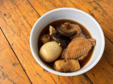 Herb, yumurta ve kanat komposto domuz eti tavuk soya sosu veya tatlı kahverengi sos (Moo Pa-lo) içinde ahşap masa, Tay geleneksel gıda üzerinde beyaz darbe.