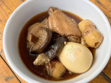 Herb, yumurta ve kanat komposto domuz eti tavuk soya sosu veya tatlı kahverengi sos (Moo Pa-lo) içinde ahşap masa, Tay geleneksel gıda üzerinde beyaz darbe.