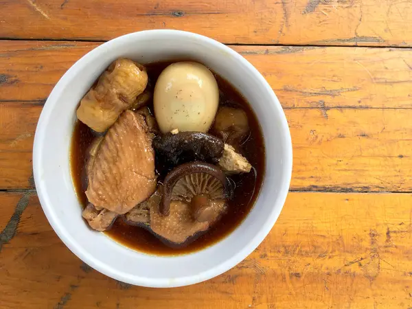 Herb, yumurta ve kanat komposto domuz eti tavuk soya sosu veya tatlı kahverengi sos (Moo Pa-lo) içinde ahşap masa, Tay geleneksel gıda üzerinde beyaz darbe.