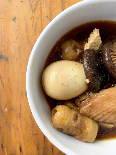 Herb, yumurta ve kanat komposto domuz eti tavuk soya sosu veya tatlı kahverengi sos (Moo Pa-lo) içinde ahşap masa, Tay geleneksel gıda üzerinde beyaz darbe.