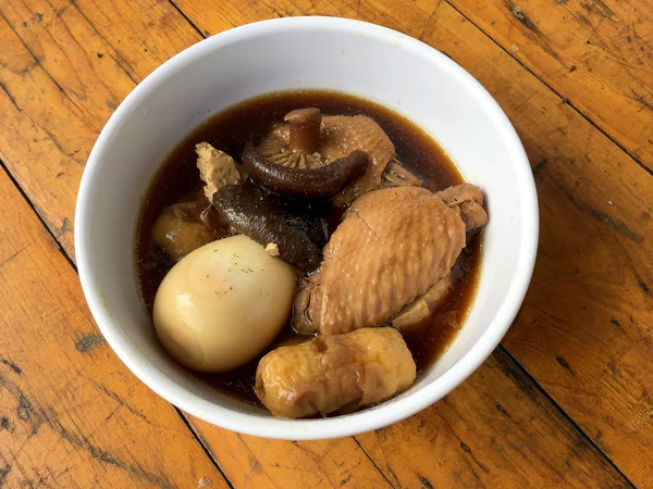 Herb, yumurta ve kanat komposto domuz eti tavuk soya sosu veya tatlı kahverengi sos (Moo Pa-lo) içinde ahşap masa, Tay geleneksel gıda üzerinde beyaz darbe.