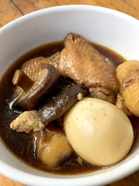 Herb, yumurta ve kanat komposto domuz eti tavuk soya sosu veya tatlı kahverengi sos (Moo Pa-lo) içinde ahşap masa, Tay geleneksel gıda üzerinde beyaz darbe.