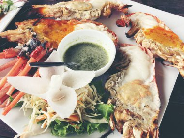 Lezzetli ızgara dev nehir karides adet biber ve maydanoz merkezinde, ahşap masa, küçük kase Soya soslu beyaz çanak üzerinde yukarıdan görüntüleyin. Tay tarzında gıda.