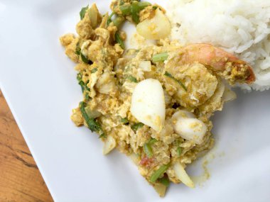 Köri ve toz köri içinde deniz ürünleri ahşap masa üzerinde beyaz tabak içinde Tayland Yasemin pirinç ile tavada kızartılmış yumuşak yengeç. (Poo-Pad-Phng-Ka-Ree Tayland gıda)