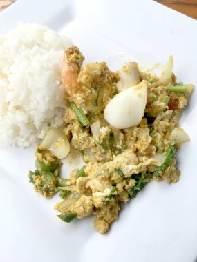 Köri ve toz köri içinde deniz ürünleri ahşap masa üzerinde beyaz tabak içinde Tayland Yasemin pirinç ile tavada kızartılmış yumuşak yengeç. (Poo-Pad-Phng-Ka-Ree Tayland gıda)