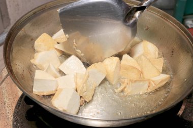 Pişirme tofu kızartma yağı, soya peyniri kızartma adet özel bir ızgarada pişirme süreci mutfakta pan. Vejetaryen yemekleri. Soya soya peyniri ızgara. Kızarmış Tofu tarifi, yumuşak odak.