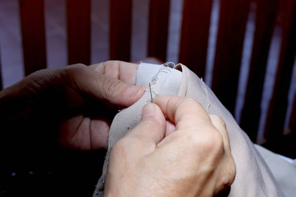 Mãos de costureira no trabalho na cadeira de madeira com seu pano, brinquedos macios feitos à mão costura com feltro e agulha — Fotografia de Stock