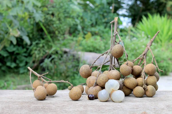 Longan taze. Longan ve kabuğu bir grup yeşil doğal arka plan Bahçe ahşap bir zemin üzerine Kuzey Tayland. tatlı ve hoş kokulu, kahverengi meyve bir küre gibi görünüyor.