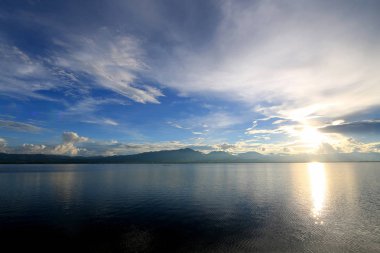 Güzel gün batımı ve dağ ve bulutlar ve Günbatımı ile akşam gökyüzü arka plan için göle yansıyan. Kırsal manzara renkli gökyüzü gün batımında altında şafak Sunrise.