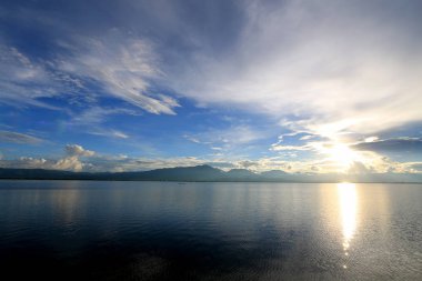 Güzel gün batımı ve dağ ve bulutlar ve Günbatımı ile akşam gökyüzü arka plan için göle yansıyan. Kırsal manzara renkli gökyüzü gün batımında altında şafak Sunrise.