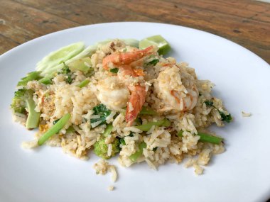 Lezzetli karides kızarmış pilav ahşap masa üzerinde beyaz tabak içinde. Tayland gıda.