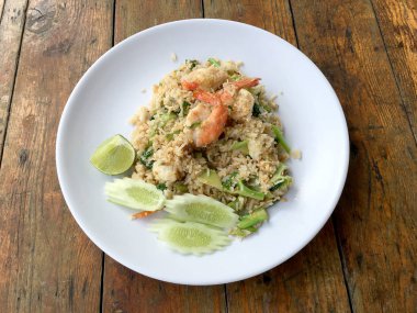 Lezzetli karides kızarmış pilav ahşap masa üzerinde beyaz tabak içinde. Tayland gıda.