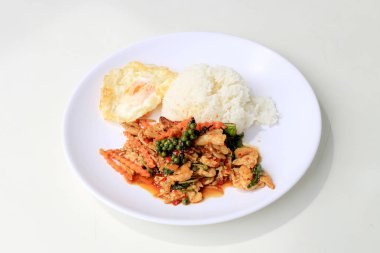 Yasemin pirinç beyaz arka plan üzerinde beyaz tabak içinde kavrulmuş chili Yapıştır ve taze Piper nigrum kızarmış tavuk karıştırın. Tay tarzında gıda.