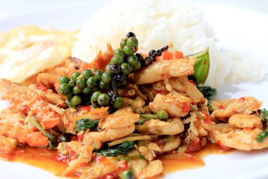 Yasemin pirinç beyaz arka plan üzerinde beyaz tabak içinde kavrulmuş chili Yapıştır ve taze Piper nigrum kızarmış tavuk karıştırın. Tay tarzında gıda.