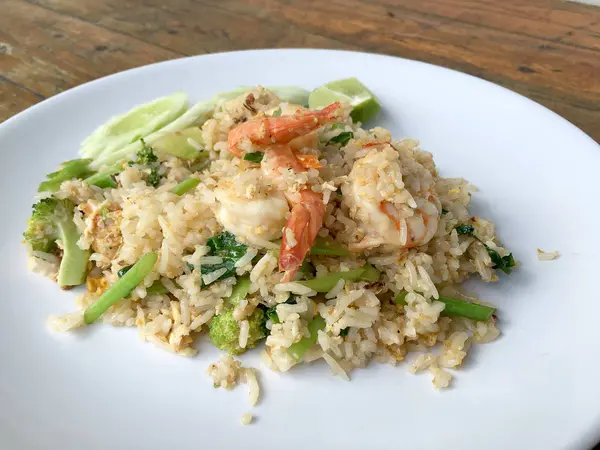 Lezzetli karides kızarmış pilav ahşap masa üzerinde beyaz tabak içinde. Tayland gıda.