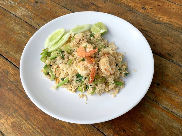 Lezzetli karides kızarmış pilav ahşap masa üzerinde beyaz tabak içinde. Tayland gıda.